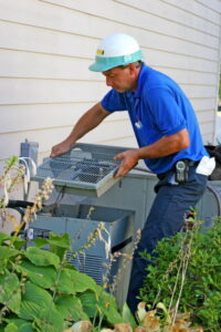 AC-technician-opening-outdoor-AC-unit-to-access-the-compressor
